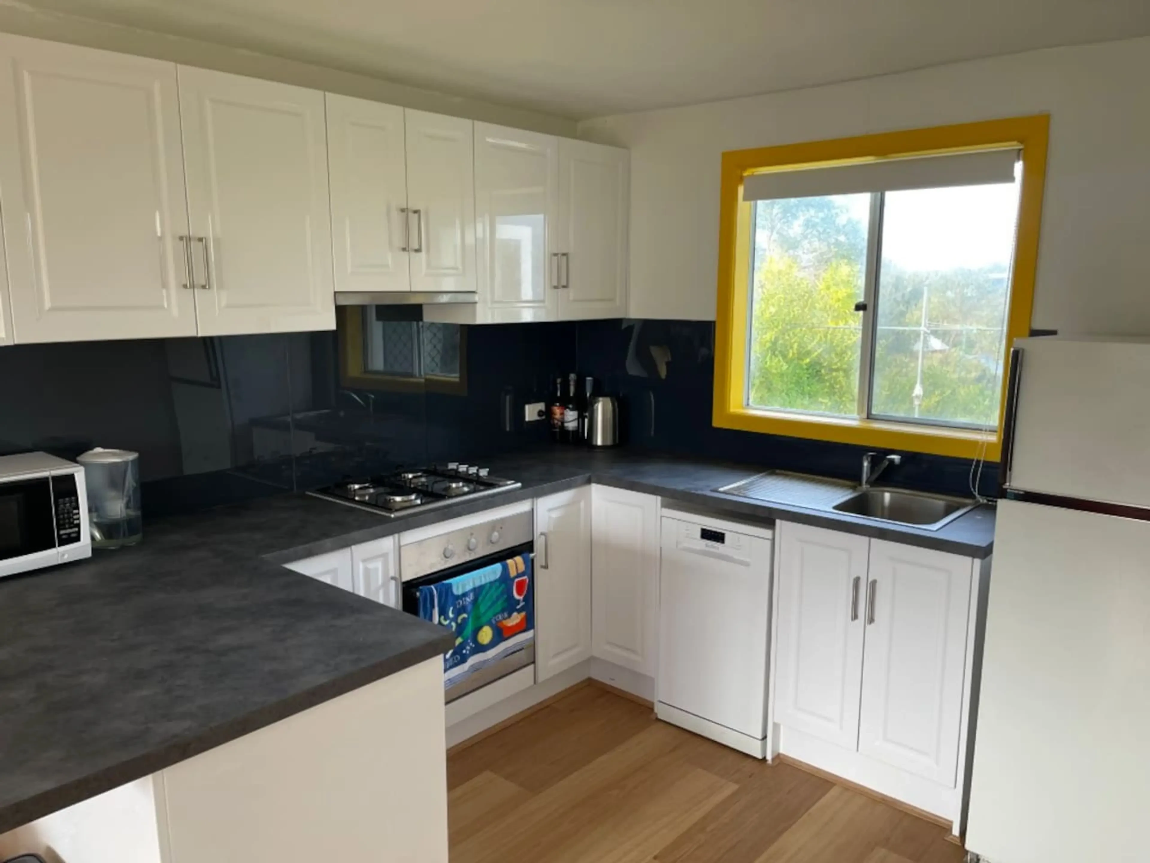 Cosy Tin Shack kitchen with yellow window frame