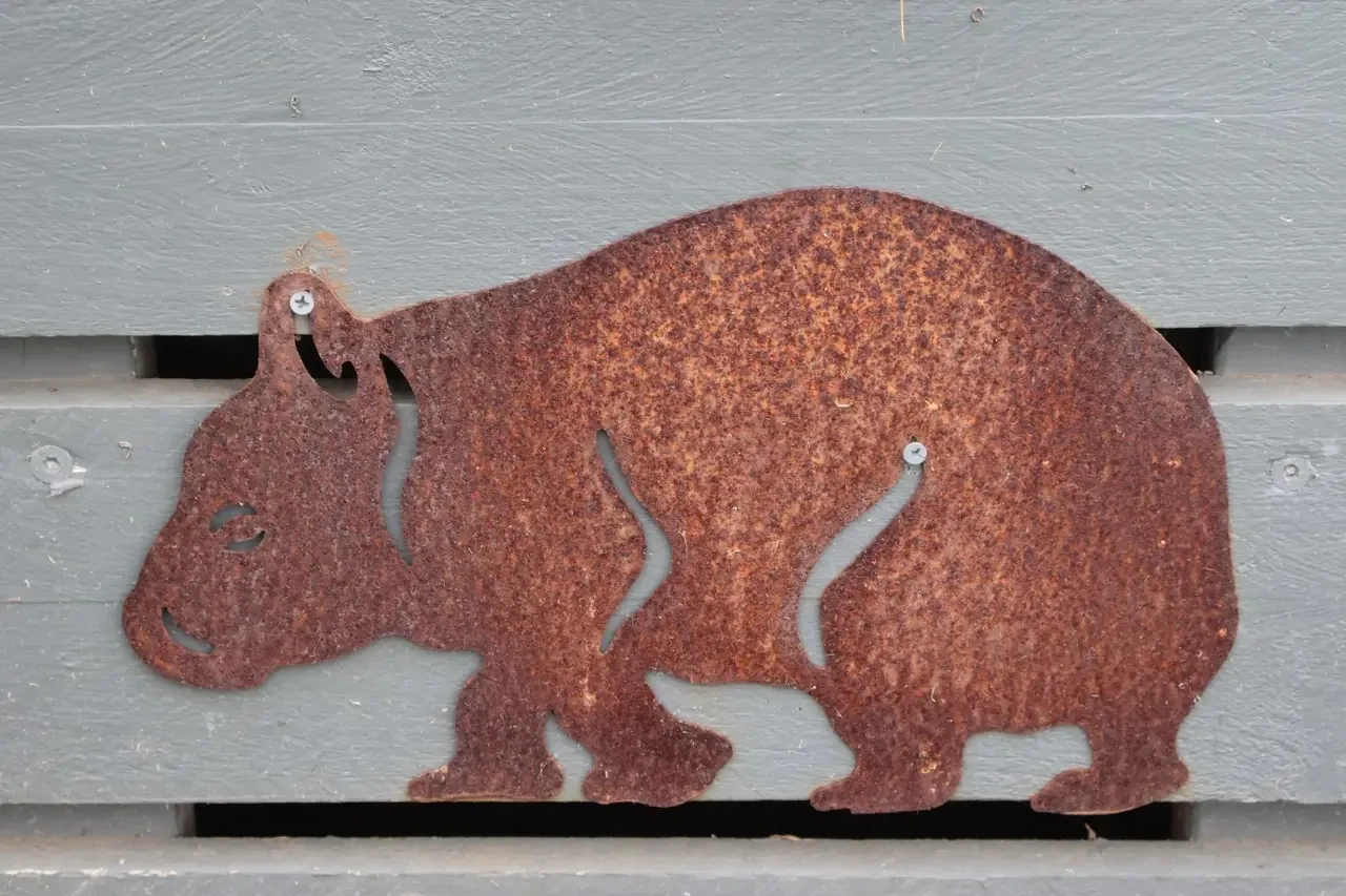 Rusty wombat metal sculpture on the fence at Far View