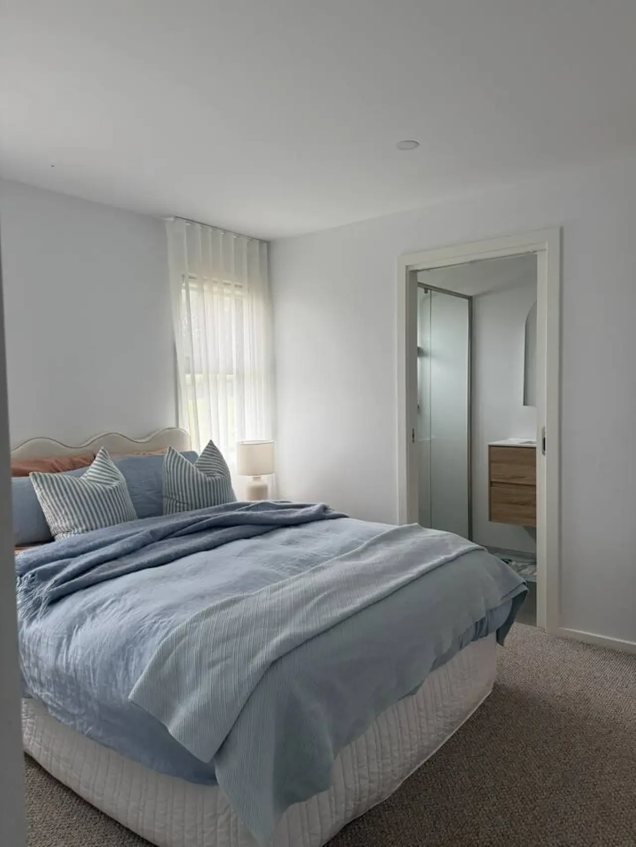 Lancaster Lodge master bedroom with blue linen and ensuite doorway
