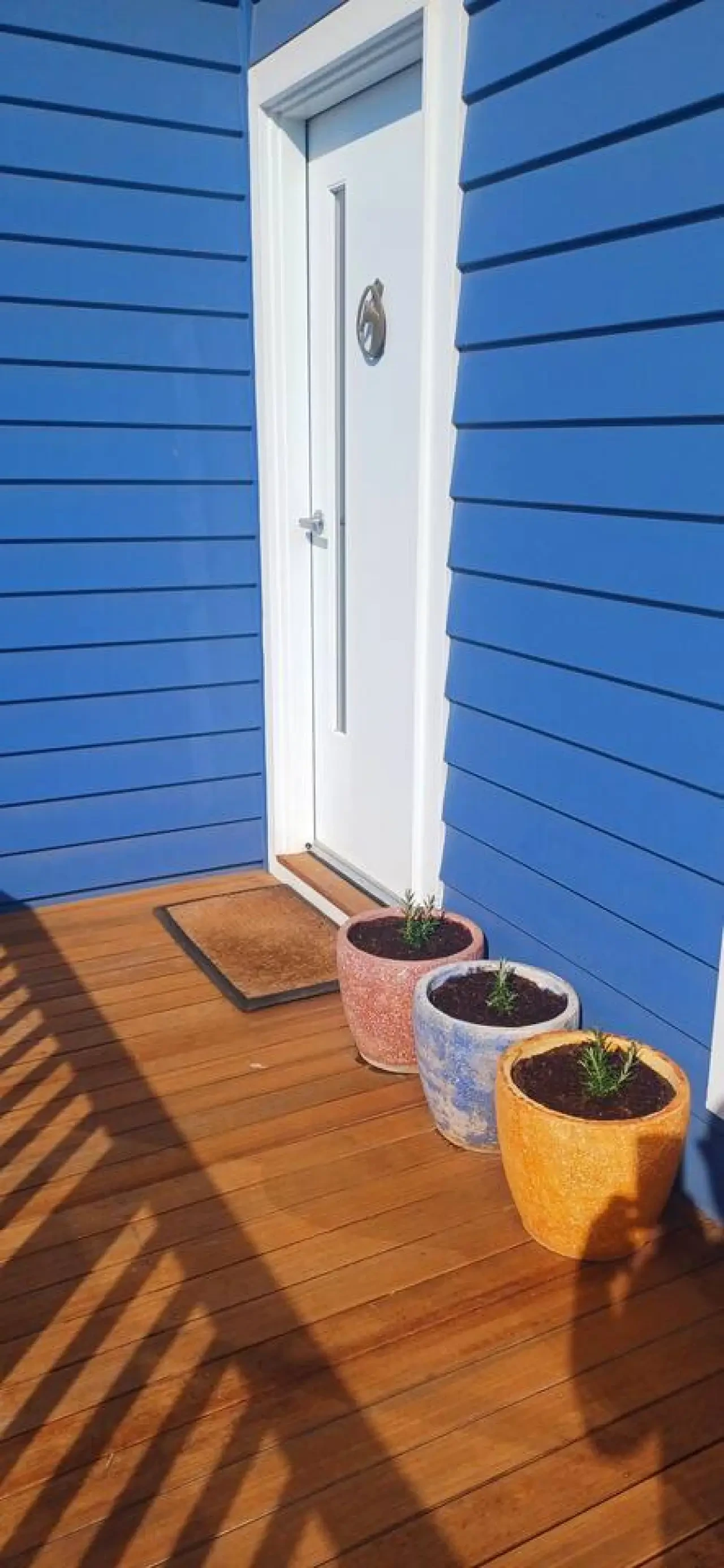 Ocean Blue — blue exterior with front door and deck pots