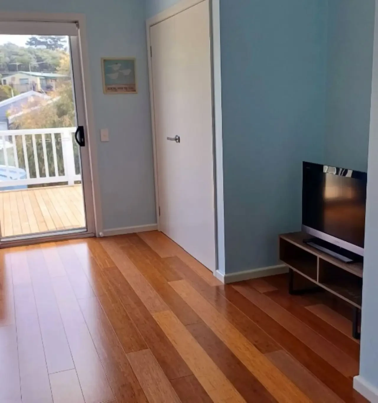 Ocean Blue — living area with TV and deck access