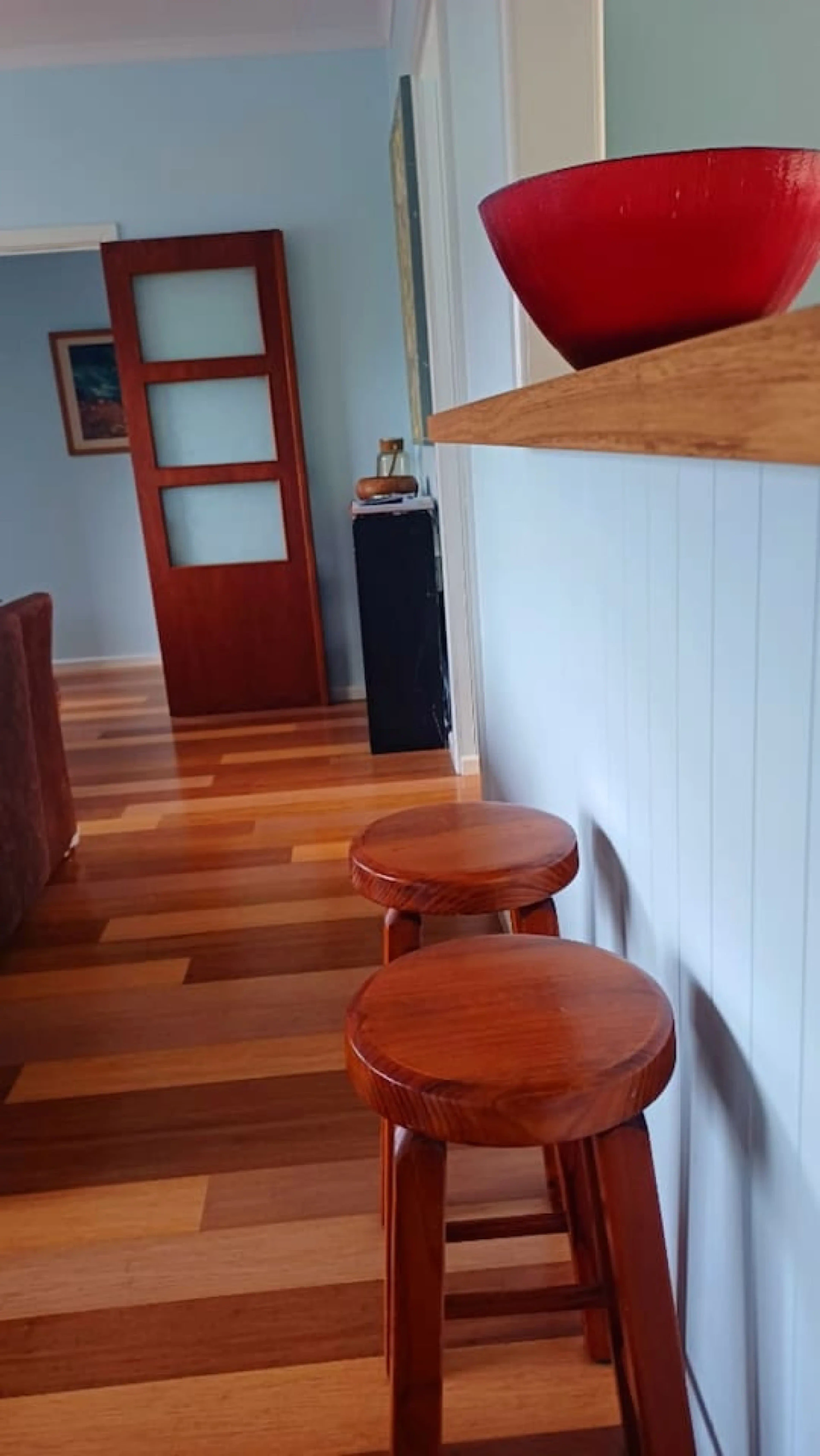 Ocean Blue — kitchen bar with timber stools and red bowl