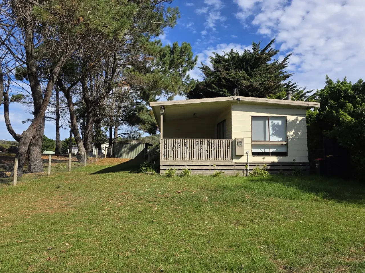 Full exterior view with lawn and pine trees