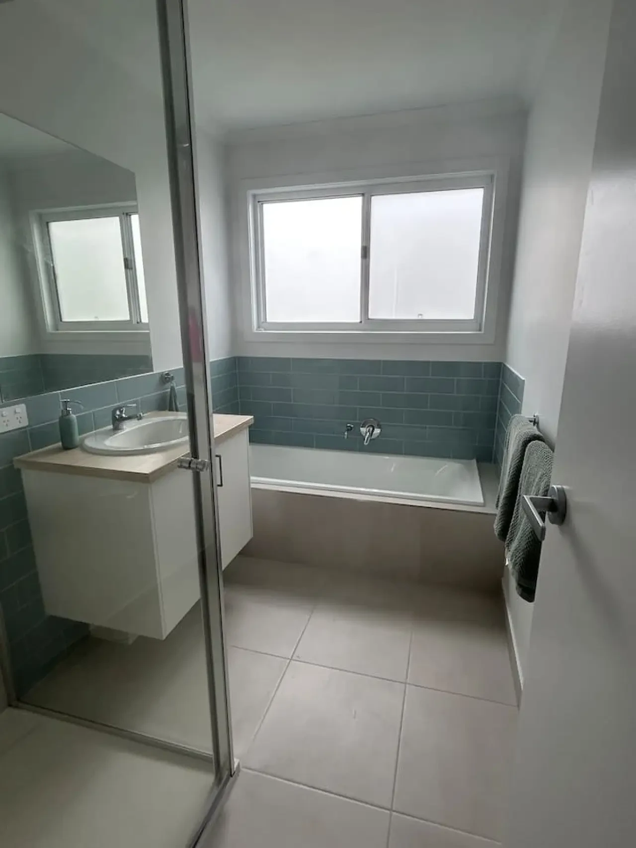 Roo Views bathroom with bathtub and teal tile surround