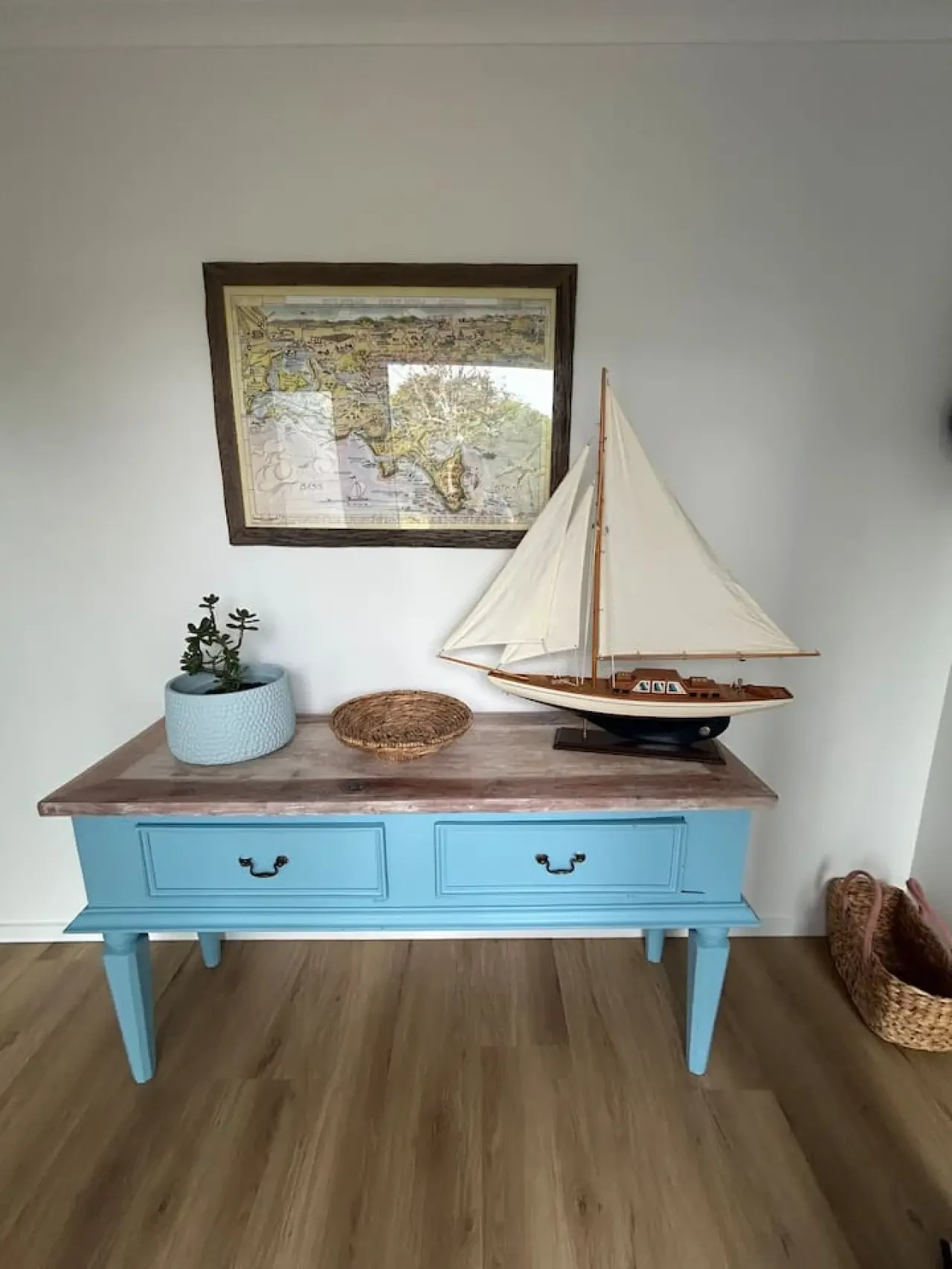 Roo Views coastal console table with sailboat model and map artwork