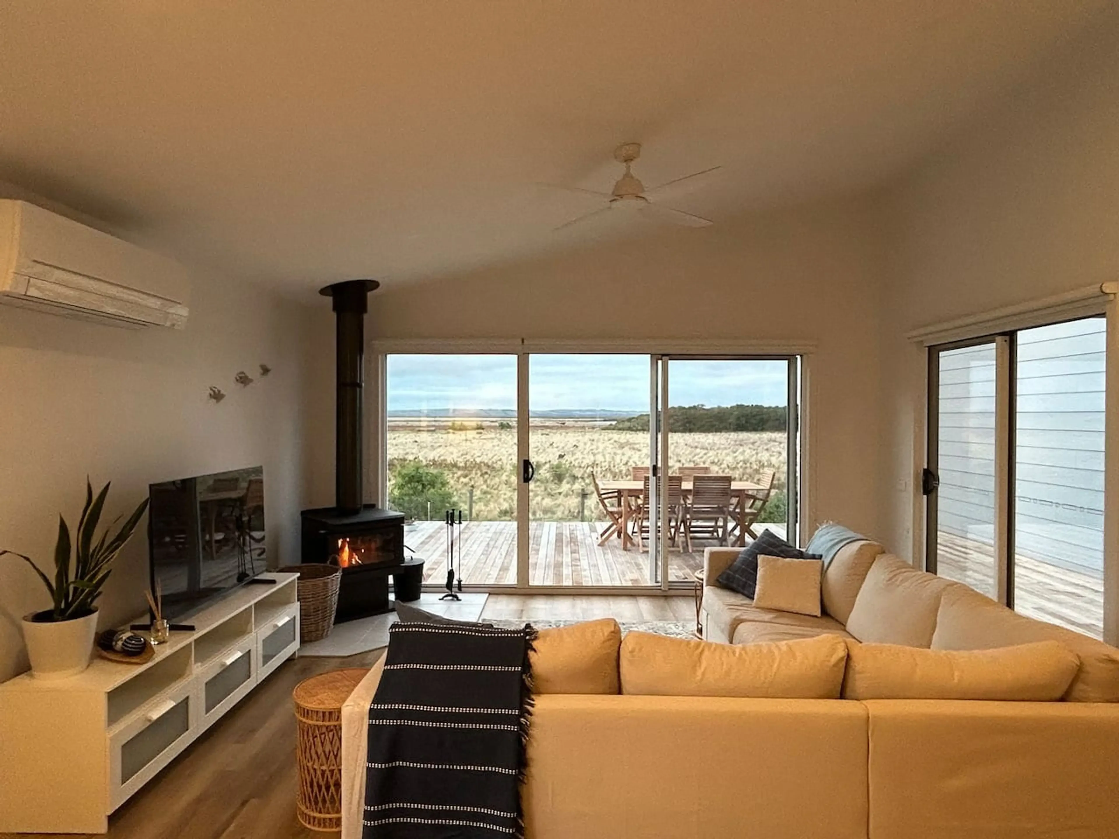 Roo Views living room with wood fire and deck views
